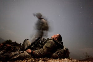 A US soldier of 2-12 Infantry Task Force Mountain Warrior takes a break during a night mission near Honaker Miracle camp at the Pesh valley of Kunar Province 12 August, 2009
