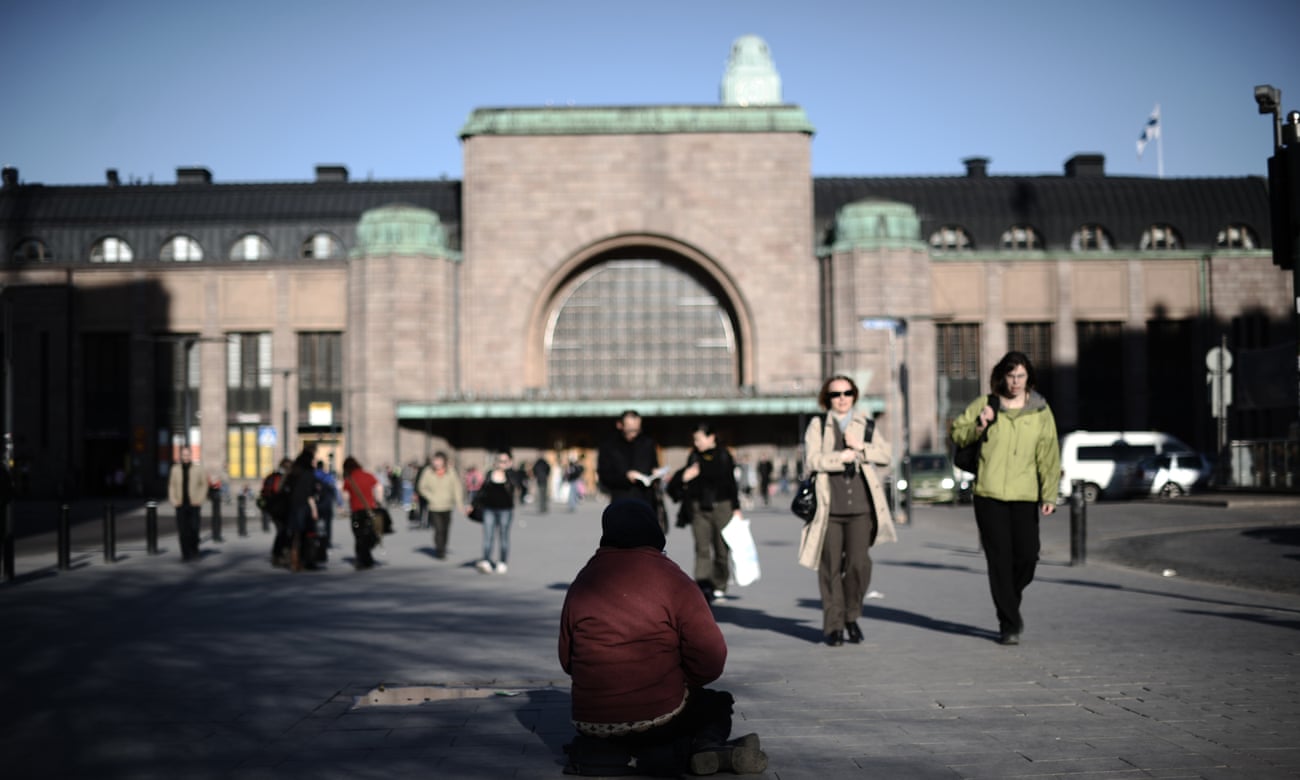 A homeless woman sits outside downtown Helsinki central station in 2011.