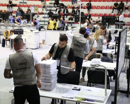 Members of the electoral commission count ballots in a sports hall