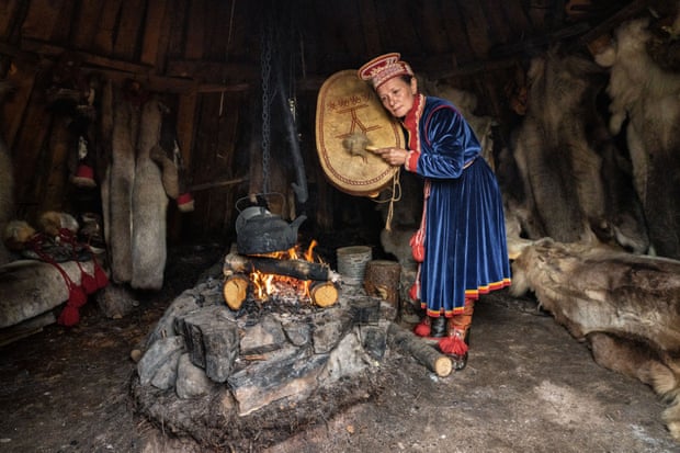 Elena Yakovleva, Uliana’s aunt, prepares her drum to perform a ritual in front of a sacred stone in the Sami mini-village that she has reconstructed for tourists