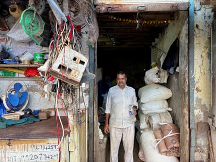 Sagar Gupta stands in the doorway of a derelict building next to a pile of large bags