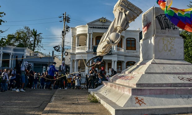 Protestors topple a statue of Christopher Columbus during a demonstration against government in Barranquilla, Colombia on June 28, 2021.