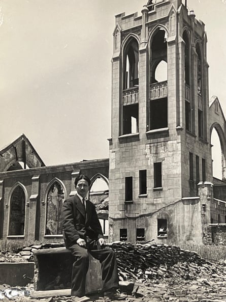 Kyoshi Tanimoto wearing a suit sitting among the ruins