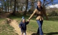 Michelle Johnstone walking down a path through a park or wood with Fergus, a toddler, walking beside her, holding her hand