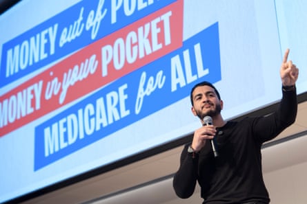 a man points while holding a microphone