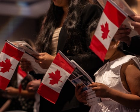 a women and child holding a flag and booklet