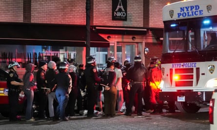 New York City police officers loads detained protesters on to a bus after entering a barricaded building at Columbia University.