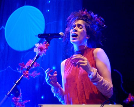 Heap in red top sings into microphone with eyes shut