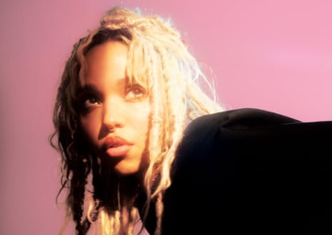 A portrait of FKA twigs with blond hair against a pink background