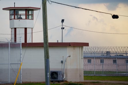 A Louisiana corrections officer looks out from a tower by Camp 57 at Angola prison.