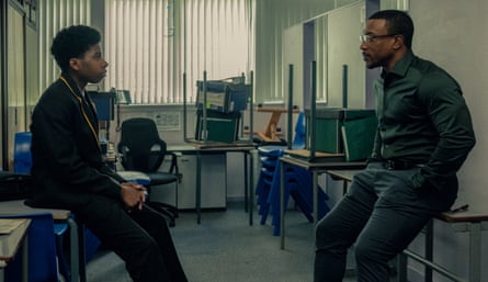 Ashley Walters sits opposite the young man playing his son in an empty school storeroom