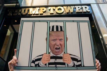 A protestor calling for Donald Trump’s arrest holds a sign in front of Trump Tower the morning after the FBI raid on Mar-a-Lago in August.