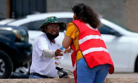 Salvation Army volunteer Soila Arias gives water to a man at their Valley Heat Relief Station, Tuesday, July 11, 2023 in Phoenix. Even desert residents accustomed to scorching summers are feeling the grip of an extreme heat wave smacking the Southwest this week. Arizona, Nevada, New Mexico and Southern California are getting hit with 100-degree-plus Fahrenheit and excessive heat warnings.