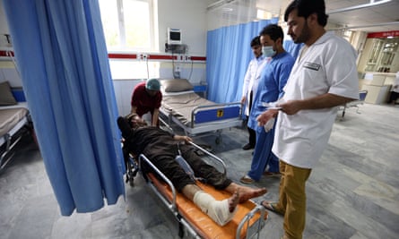 Afghan health workers tend to a man injured in the attack in Kabul on Tuesday