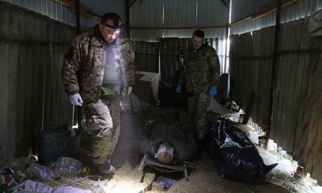 Military medics looks at a body of a Ukrainian soldier that was brought to a frontline field hospital, near Bakhmut, Donetsk region, Ukraine.