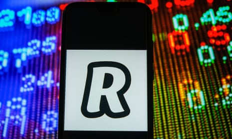 The Revolut logo seen displayed on a smartphone with stock market prices in the background