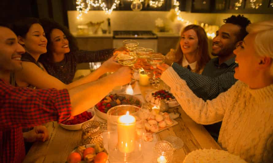 Friends toasting champagne glasses at candlelight table