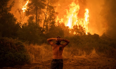 A resident watches a wildfire near the village of Pefki on Evia island, Greece, on 8 August.