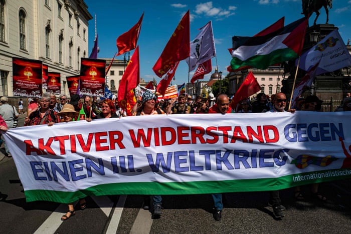 Protesters carry a banner reading “active resistance against a third world war” during a demonstration in Berlin.