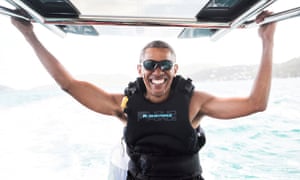 Barack Obama sits on a boat during a kitesurfing outing with British businessman Sir Richard Branson