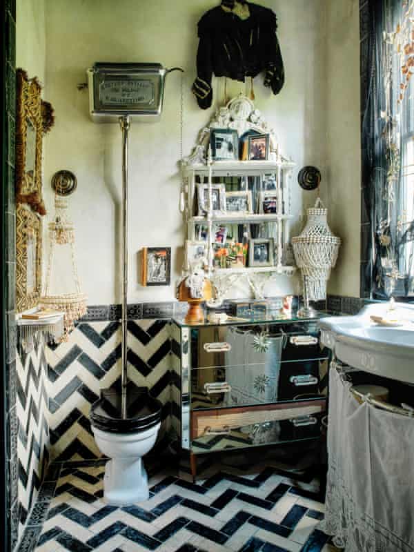 A bathroom with black and white zigzag tiling and antique furniture