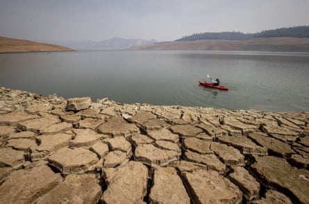 A kayaker paddles in Lake Oroville as water levels remain low.
