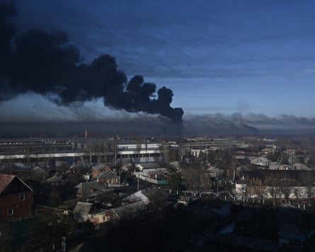Wide shot of smoke rising over houses and other buildings
