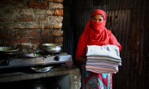 Garment worker, Forida holds sweaters made in Bangladesh for an international brand.