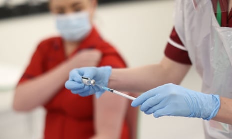 A nurse practitioner fills a needle with the Covid-19 vaccine before administering it, 8 December 2020