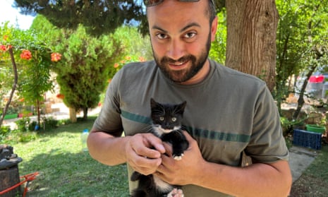 The Reuters visuals journalist Issam Abdallah holds a kitten while posing for a picture in Saaideh, Lebanon, in 2023.