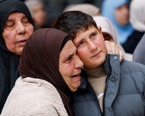 A crying woman put her arm around a boy