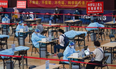 Residents register before getting inoculated against Covid-19 at a vaccination site in a stadium in Nanjing, the capital of Jiangsu province in eastern China