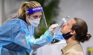 A passenger has their throat and nose swabbed for Covid-19 inside a pre-departure testing clinic at the departures hall at Sydney Airport.
