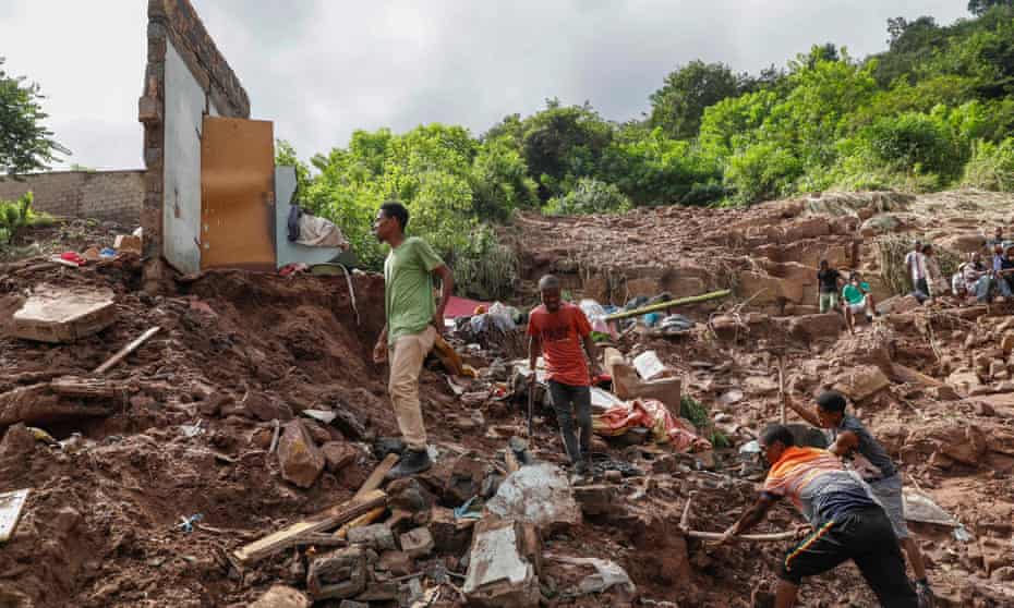 Family members assist with clearing debris as South African police rescue units search for 10 people missing in KwaNdengezi township outside Durban, South Africa, on Friday.