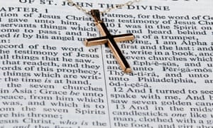 Una croce d'oro su una pagina della Bibbia