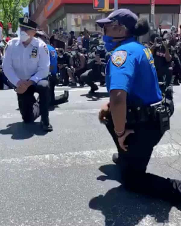 New York police officers kneel along with protesters after protesters said they asked them to do so, in this still frame obtained from social media video in Queens, New York, on Sunday.