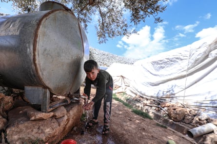 A child washes his hands at a water tank in a camp in Idlib, north-west Syria.