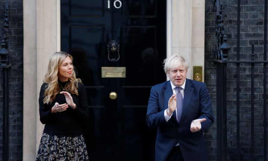 Prime Minister Boris Johnson and partner Carrie Symonds applaud outside 10 Downing Street.