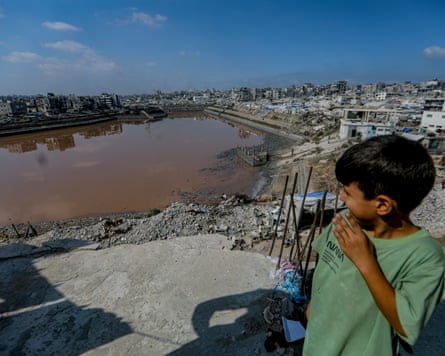 A Palestinian boy stands near the edge of the Sheikh Radwan reservoir in Gaza City