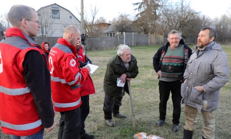 Ukrainian Red Cross workers talk to old men as an aid team delivers humanitarian goods to towns and cities liberated from Russian invaders in the Kyiv Region, northern Ukraine.
