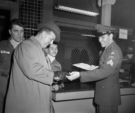 Discharged … Presley laughs as he hands Parker his mustering out pay.