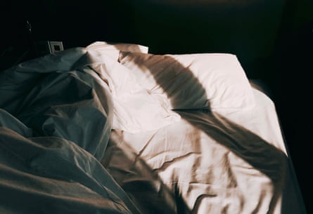 An unmade bed with morning light.