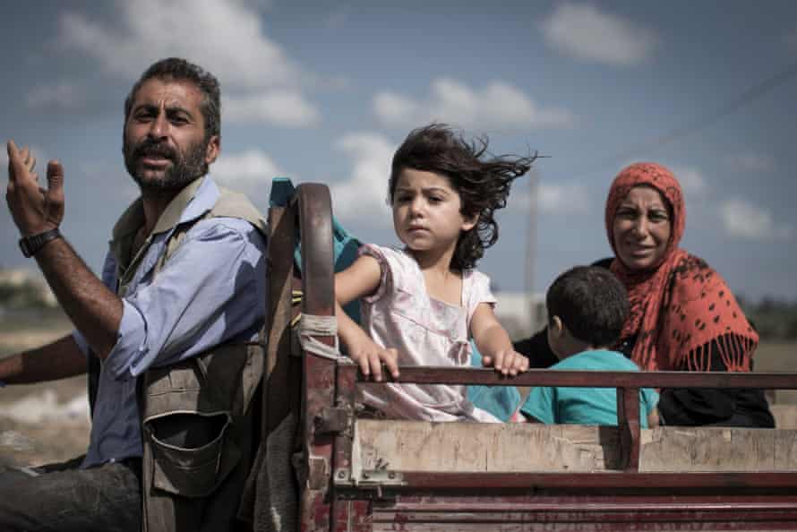 A Palestinian family who fled their homes en route to seek shelter in a UN school in Khan Younis in the Gaza Strip. 18 July 2014.