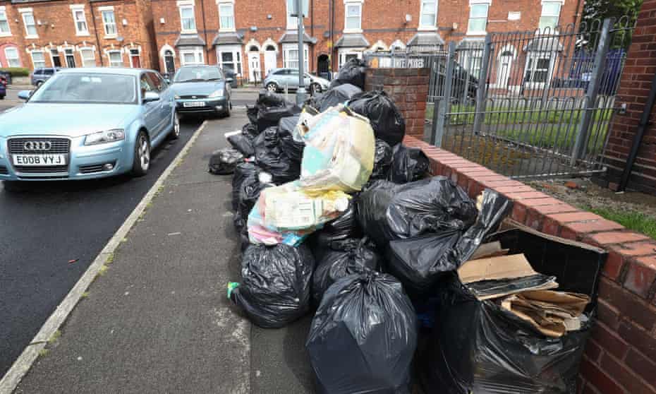 Rubbish bags piled high on a pavement in Birmingham