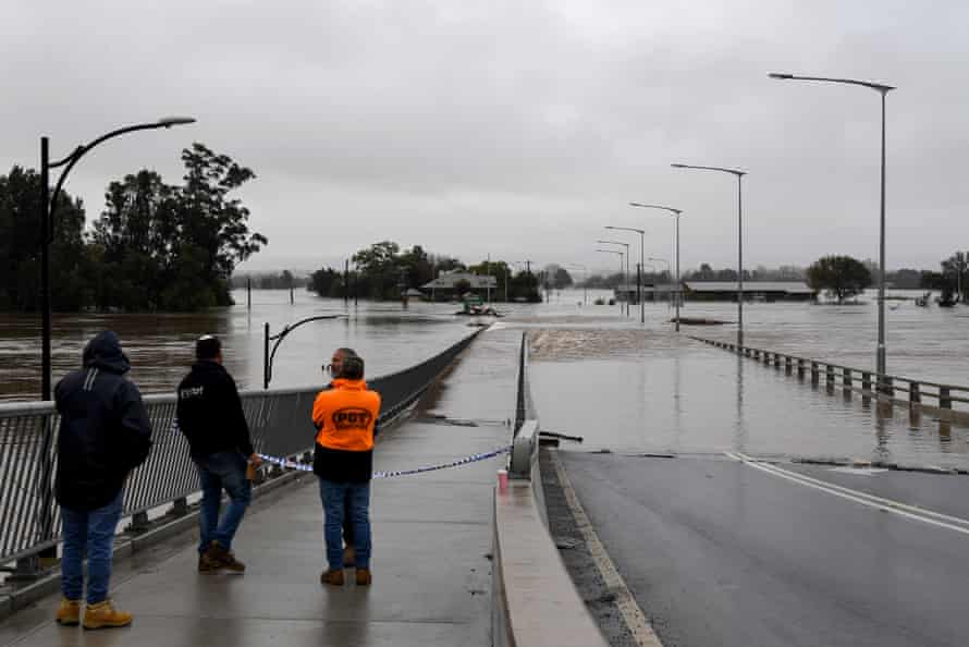 Members of the public look on as the Windsor Bridge is submerged under floodwater from the swollen Hawkesbury River, in Windsor, north west of Sydney, Monday, July 4, 2022.