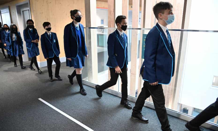 Students wear protective face masks as they walk between classrooms