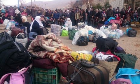 Syrians wait for the arrival of an aid convoy in the besieged town of Madaya, 11 January 2016