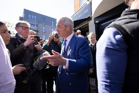 Nigel Farage talking to people on a crowded pavement