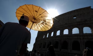 A tourist shelters from the sun near the Colosseum in Rome