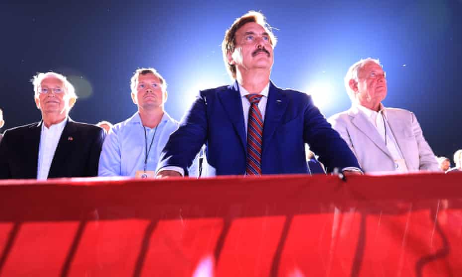 Mike Lindell, center, listens to Donald Trump at a rally in Cullman, Alabama, in August 2021. 
